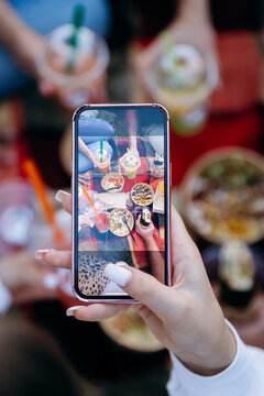 Smartphone capturing picnic takeaway bowls and drinks for social media