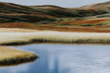 Oversized Pastel Geometric Form Resting in Rainwater Basin Among Rolling Icelandic Hills, Overcast Summer Light, Minimal Landscape Installation Concept