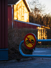 Sign showing no moped allowed in residential area of Sweden during sunset