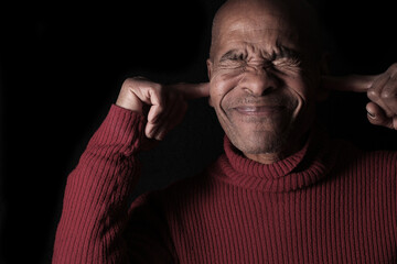 Obraz premium deafness suffering from deafness and hearing loss Senior man cupping his ear having difficulty hearing on gray background with people stock photo stock image