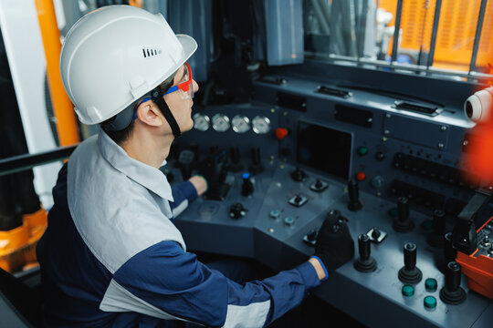 Young caucasian male operating mining machinery in industrial control room