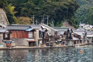 Obraz premium Ine Fishing Village, Kyoto prefecture, Japan, Ine-ura landscape coastal view, Funaya, traditional wooden boat houses, Ine Bay during boat tour cruise, Yoza District, in a autumn fall day