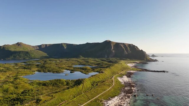 forward drone flight aboe sandy beach with bolders on Vesteralen, Vester&aring;len islands. Bleikmorenen nature reserve at side. Mountains in background. Beautiful nature in arctic Norway. Travel destinatio