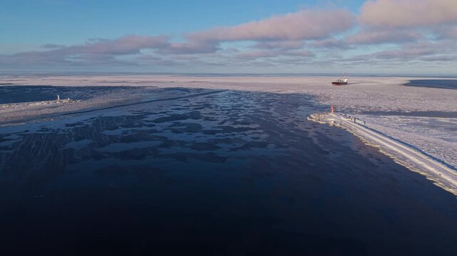 Frozen waterway with distant vessel. Aerial perspective of frozen water passage and shipping vessel