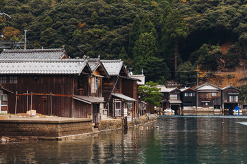 Obraz premium Ine Fishing Village, Kyoto prefecture, Japan, Ine-ura landscape coastal view, Funaya, traditional wooden boat houses, Ine Bay during boat tour cruise, Yoza District, in a autumn fall day