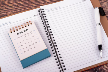 High angle view of April 2026 desk calendar and personal organizer