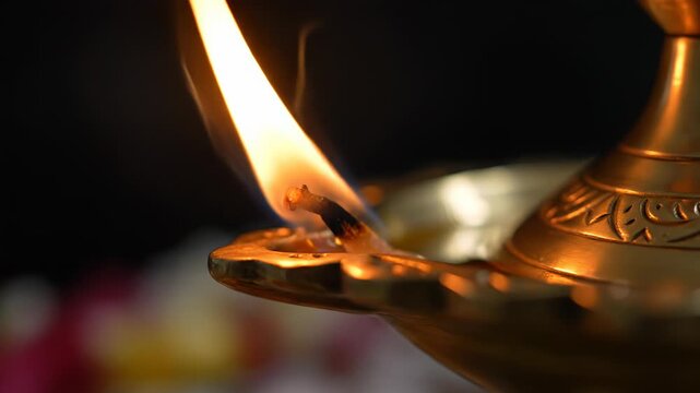 Close Up Of A Lit Brass Oil Lamp With Orange Flame And Dark Background Detailed Decorative Engraving Visible On The Lamp