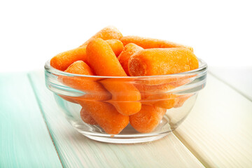 baby carrots on wood background on white