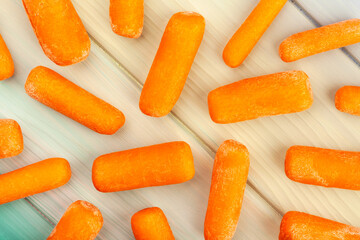 baby carrots on wood background top view