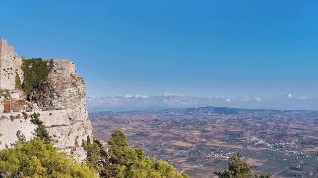 Scenic panoramic view from the Castle of Balio in Erice, Sicily, showcasing expansive landscapes, rolling hills, and distant coastline under a clear blue sky