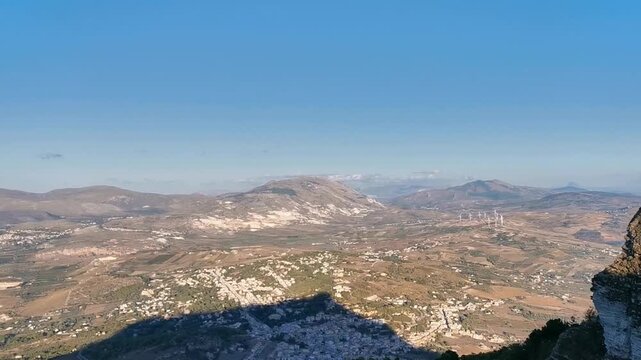 Scenic view of the Castle of Balio in Erice, Sicily, overlooking the lush landscape and coastline, showcasing the historical architecture against a clear blue sky