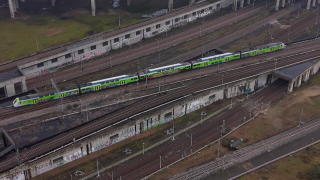 Modern Train on Rails: An aerial perspective captures a sleek, modern train gliding along a complex network of railway tracks, symbolizing progress, efficiency, and the dynamism of modern transport.