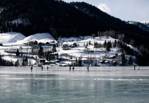 silhouette of an ice skater on a frozen Weissensee lake in winter