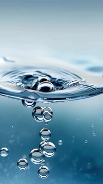 Vertical macro water surface ripple with rising air bubbles in blue liquid slow motion