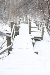 Snow Covered Wooden Boardwalk With Handrails In Winter Forest