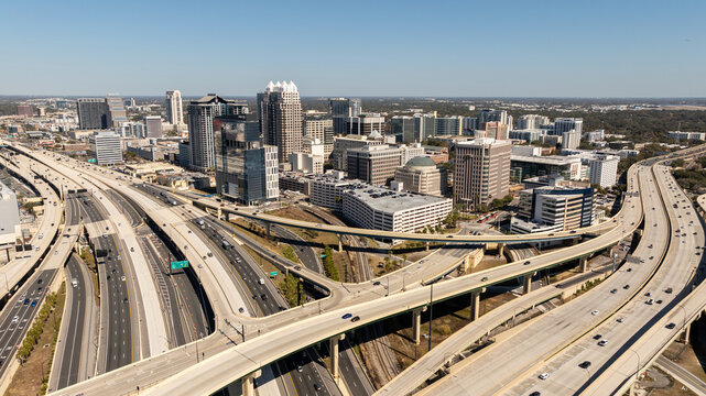 An aerial perspective captures downtown Orlando&rsquo;s skyline framed by the sweeping curves of the I-4 and SR-408 interchange.