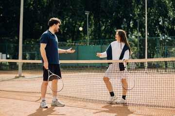 Obraz premium Couple tossing tennis ball enjoying outdoor game