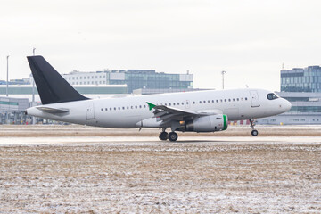 Generic unbranded commercial passenger airplane taxiing on airport runway in winter