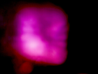 A blurry purple light with a black background. The light is blurry, which gives the image a sense...