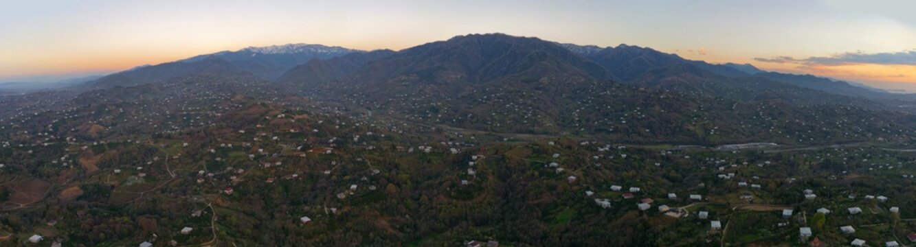 Panoramic of the snow-capped Caucasus Mountains at sunset
