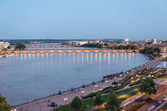 Looking out over the city of Bordeax from a ferris whell in the early evingen. City lights mix with the blue hour.