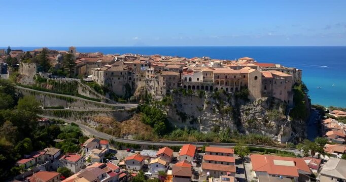 Aerial view of the historic center of Tropea, in the province of Vibo Valentia, Calabria, Italy. It is a town perched on a hill, with the Mediterranean Sea and the island of Stromboli on the horizon.