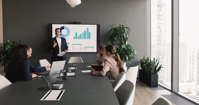 Team leader presenting financial charts and performance graphs on screen, engage in strategic planning, data analysis, and collaborative decision-making during corporate meeting in office boardroom