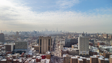 Snow dusted midtown manhattan skyline and central park from above on a cloudy winter day, bustling 7th avenue and layered rooftops stretching across the urban panorama