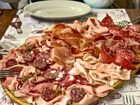 Traditionelle italienische Vorspeise (Tagliere) mit verschiedenen Wurstsorten in einem typischen Restaurant in Rom 