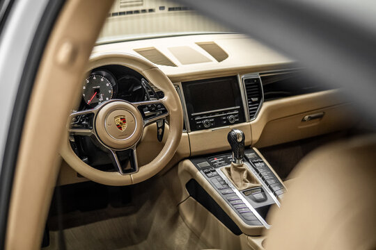 Porsche Macan S - Modern Car Interior Concept For Automobile And Technology. Porsche Macan S beige leather interior, steering wheel, badge, emblem. German SUV car. 