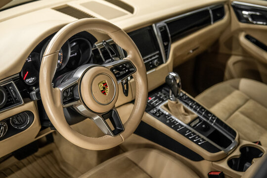 Porsche Macan S - Modern Car Interior Concept For Automobile And Technology. Porsche Macan S beige leather interior, steering wheel, badge, emblem. German SUV car. 