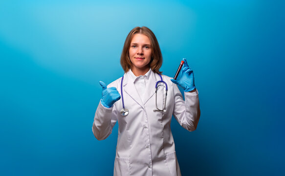 The doctor holds a tube of blood and gives a thumbs up. Portrait of a Doctor or laboratory assistant holding a blood sample. The concept of Laboratory research or CheckUp