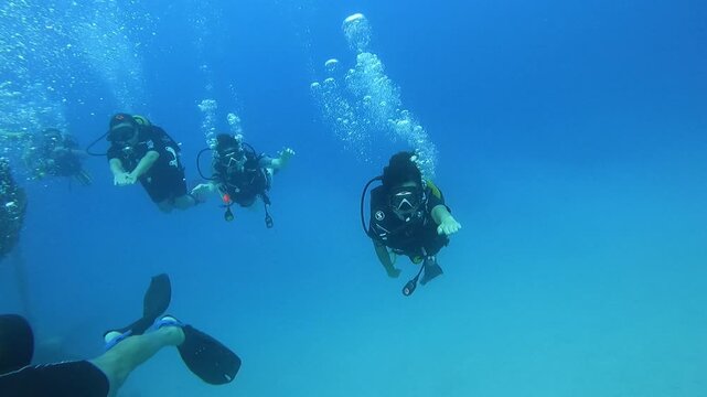 Antalya , Turkey - 08.19.2025 -  A captivating underwater scene featuring multiple scuba divers navigating through vibrant corals and marine life in a clear blue ocean, oc01