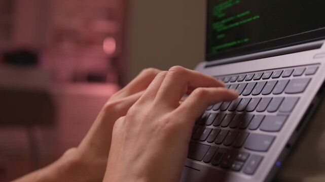 Person programming on laptop with relaxed posture and soft lighting. Individuals engaged in debugging workflow while sitting on couch in cozy environment during nighttime