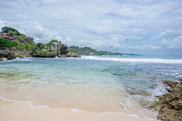 Obraz premium Beautiful Mbuluk Beach Landscape with White Sand and Coral Cliffs in Gunung Kidul