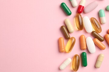 Many different pills on pink background, flat lay. Space for text