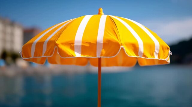 Sunny Umbrella and Serene Waters: A vibrant yellow and white striped beach umbrella stands proudly against a backdrop of tranquil blue waters, offering a sense of relaxation and leisure.