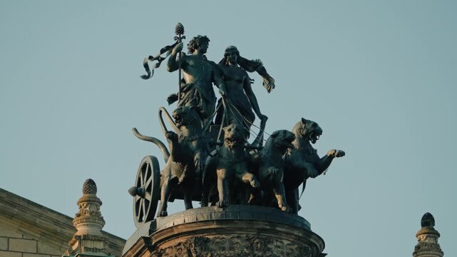 a long-range still shot of birds fly around the Panther Quadriga sculpture located on top of the Semper Opera House in Dresden, Germany