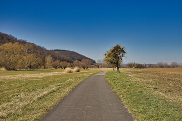 Obraz premium Idyllischer Unstrutradweg mit Blick auf die Landschaft und Wohnhäuser bei strahlend blauem Himmel, zwischen Freyburg und Laucha, Burgenlandkreis, Sachsen-Anhalt, Deutschland