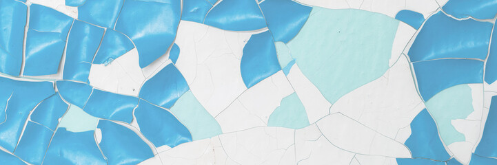 Blue peeling paint on the wall. Old concrete wall with cracked flaking paint. Weathered rough painted surface with patterns of cracks and peeling. High resolution texture for background and design.