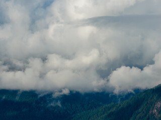 Clouds Hover Over Mountain Ridge With Dense Forest Below Near Howe Sound, BC, Canada