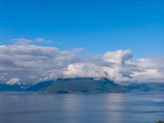 Obraz premium Calm Blue Waters Over Cloudy Mountains in Howe Sound, BC, Canada at Dawn