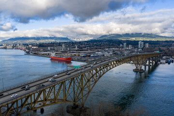 Fototapeta premium Burnaby Harbour Bridge Over Water With City Skyline and Mountain View, Vancouver Area