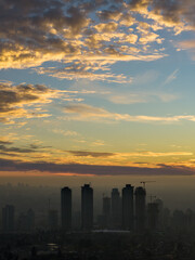 Fototapeta premium Dramatic Sunset Over Burnaby Skyline With Cranes And City Silhouette In Canada