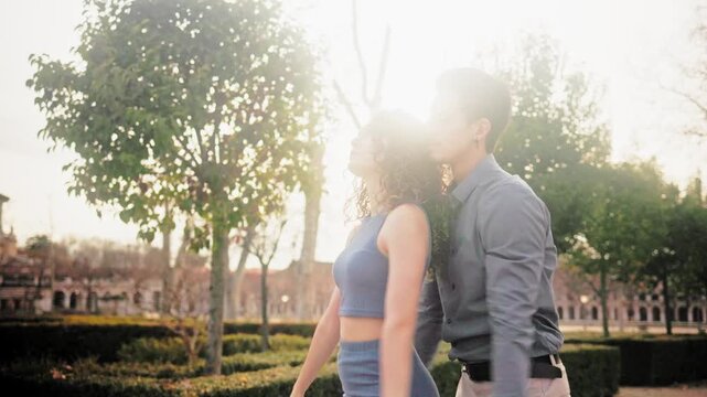 Romantic hispanic couple dancing bachata in a park at sunset
