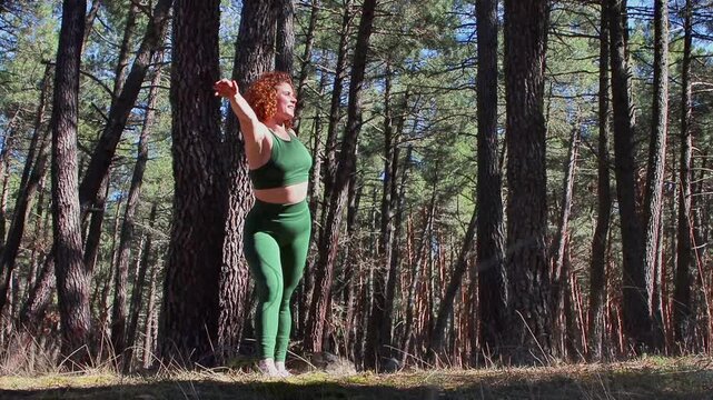 Yoga instructor performing tree pose variations in forest