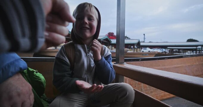 Camera man playing rock, paper, scissors with little boy on Japanese boat
