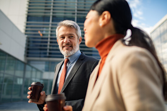Business colleagues talking with coffee outside office