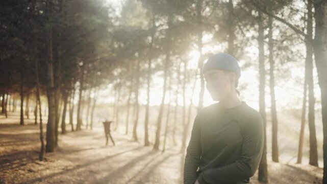 Urban dancer freestyling hip hop in a forest at sunset