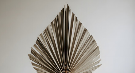 A captivating and intricate abstract art piece crafted from meticulously folded pages, resembling a stylized leaf or a fanned book, showcasing unique texture and design
